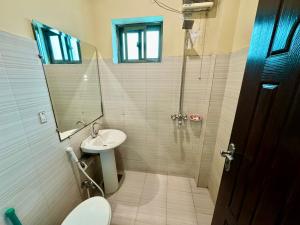 Shelton Hotel Lahore في لاهور: حمام مع مرحاض ومغسلة ودش