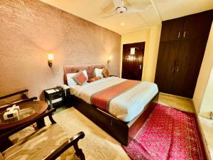 - une chambre avec un lit et une salle de bains pourvue d'un lavabo dans l'établissement Shelton Hotel Lahore, à Lahore