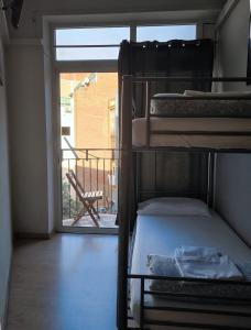 バルセロナにあるワウ ホステル バルセロナの二段ベッド2台、バルコニーが備わる客室です。