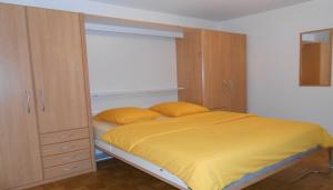 ein Schlafzimmer mit einem Bett mit einer gelben Decke in der Unterkunft Athénée 40 Residence by Homenhancement in Genf