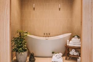 a bathroom with a tub and a potted plant at Luxury, Castle View Apartment! Spa Treatments , Windsor Town Centre in Windsor