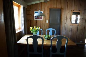a dining room table with chairs and a vase of flowers at Hunderfossen Cottages in Hafjell