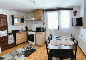 a kitchen with a table and chairs and a kitchen with a stove at Casa TOR - Moieciu de Jos in Moieciu de Jos