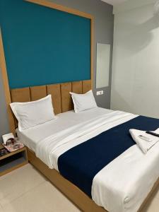 a bedroom with a large bed with a blue screen at Hotel sky palace adajan in Surat