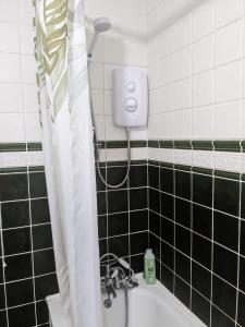 a bathroom with a shower and a bath tub at Small but bright single room not far from City Centre in Leicester