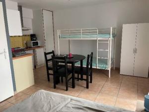 eine Küche mit einem Tisch und Stühlen sowie ein Etagenbett in der Unterkunft Grand studio 4 50m de la plage pour 4 in Argelès-sur-Mer