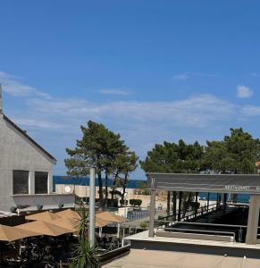 濱海阿熱萊斯的住宿－Grand studio 4 50m de la plage pour 4，享有海滩美景,设有长凳和树木