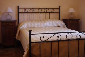 a bed in a bedroom with two night stands and two lamps at Rustico appartamento in tenuta agricola - Umbria in San Valentino