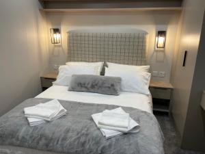Una cama con dos toallas encima. en The Drey, en Grantown-on-Spey
