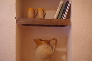 a vase sitting on a shelf next to some books at Rustico appartamento in tenuta agricola - Umbria in San Valentino