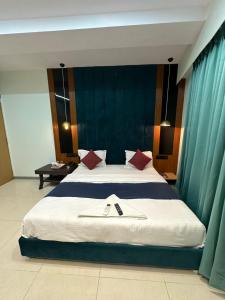1 dormitorio con 1 cama grande con almohadas rojas en Hotel sky palace adajan, en Surat