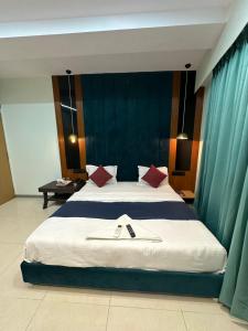 a bedroom with a large bed with red pillows at Hotel sky palace adajan in Surat