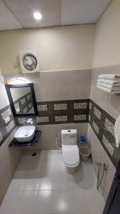 a bathroom with a toilet and a sink at J P PALACE in Kushinagar