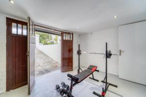 a room with a gym with a treadmill at Chic and modern house with parking garden and gym in Saint-Denis