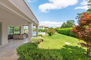 een patio met een tuin met een gazon bij Villa Fantasia for 8 people with jacuzzi and private pool in Hreljići
