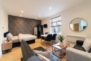 a living room with a couch and a bed at Orange Rentals- Studio apartment in the city centre of Liverpool in Liverpool