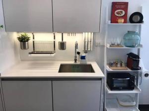 a kitchen with a sink and white cabinets at Garden 63 - Jardim da Parada - Campo de Ourique in Lisbon