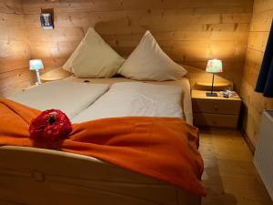 uma cama com um cobertor laranja num quarto em Landhaus de Gaspary em Seehausen am Staffelsee