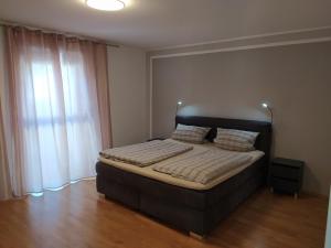 een slaapkamer met een bed met een zwart hoofdeinde en een raam bij Loft apartment in Malterdingen