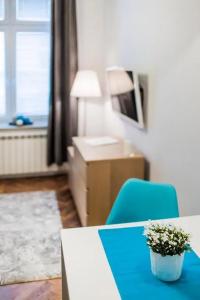 a room with a table and a blue chair with a plant at Perfect place to stay in Kraków City Center 30m2 W2 in Krakow