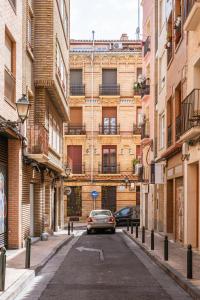 een auto die door een straat tussen gebouwen rijdt bij Villa Baturra l Centro l WiFi y Arcade in Zaragoza