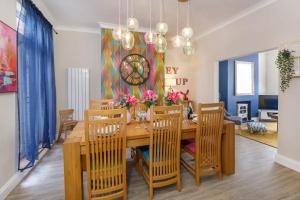 a dining room with a table with chairs and a clock at The Milton sleeps 8 close to York city centre pet friendly in York