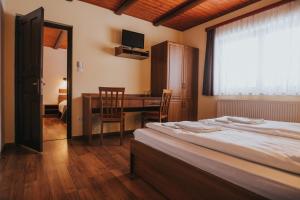 um quarto com uma cama, uma secretária e uma mesa em Complex turistic Han Pescaresc em Eremitu