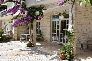 a patio with purple flowers on a building at Apartments Cipetic in Kaštela