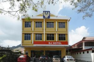 卢穆特DJ Hotel Lumut的黄色建筑上标有酒店标志