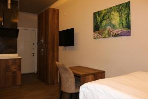 a bedroom with a desk and a bed and a tv at Center Room Otel in Yenimahalle