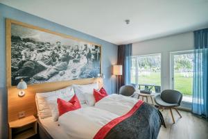 a hotel room with a large bed with red pillows at Valldal Fjordhotell - by Classic Norway Hotels in Valldal
