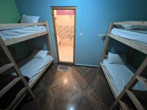 2 Etagenbetten in einem Zimmer mit Spiegel in der Unterkunft Majestic Mountain Bhaiji Guest House in Kasol