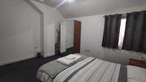 a bedroom with a bed with two towels on it at Staines City Centre Apartments in Staines upon Thames