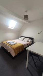 a bedroom with a bed and a table in it at Staines City Centre Apartments in Staines upon Thames