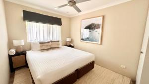 Un dormitorio con una cama grande y una ventana en Sandblu: Resort Villa on the Beach, en Broadwater