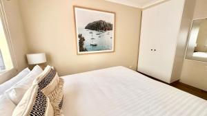 um quarto com uma cama e uma fotografia na parede em Sandblu: Resort Villa on the Beach em Broadwater