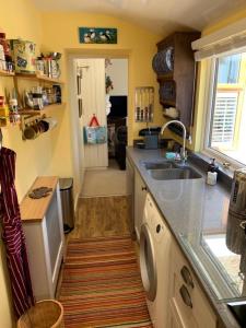 a kitchen with a sink and a dishwasher at Sunnieside Cottage in Seahouses
