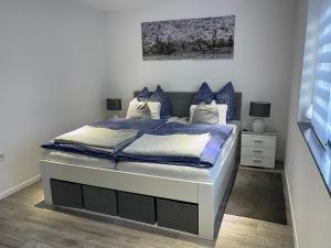 a bedroom with a bed with blue and white sheets at Maria's Ferienwohnung - Modernität trifft Eleganz in Dettingen an der Erms