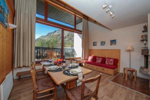 a living room with a table and a red couch at Chalet Charpoua - Happy Rentals in Chamonix