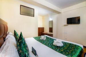 a bedroom with a bed with green and white sheets at Hotel Muscatel BhumSang Darjeeling in Darjeeling