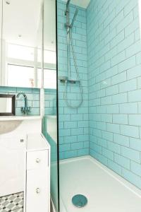 a bathroom with a shower with blue tiles at Central 1 BR Apartment *Zone 1* Elephant and Castle in London