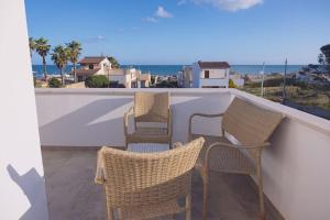 three chairs on a balcony with a view of the ocean at Villa Al Mare Guest House in Tre Fontane