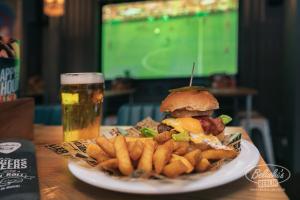 a plate with a sandwich and french fries and a glass of beer at St Christopher's Inn Berlin Mitte in Berlin