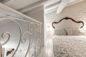 a bedroom with a white bed with a metal headboard at Olive Garden Loft - Settignano in Settignano