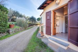 a house with a wooden door and a road at Olive Garden Loft - Settignano in Settignano