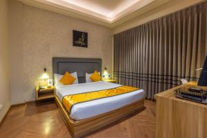 a hotel room with a bed with yellow sheets at Kohsa7 in Gurgaon
