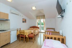a room with a kitchen and a dining room with a table at Apartments Cipetic in Kaštela
