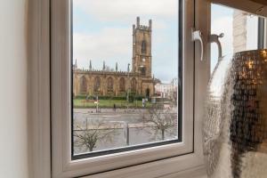 a window with a view of a church at Orange Rentals- Studio apartment in the city centre of Liverpool in Liverpool