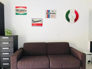 sala de estar con sofá marrón y carteles en la pared en Pizzo Beach Studios Apartments, en Pizzo