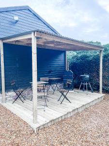 einen Pavillon mit Stühlen, einem Tisch und einem Grill in der Unterkunft Belle Vue Farm B&B in Fritham